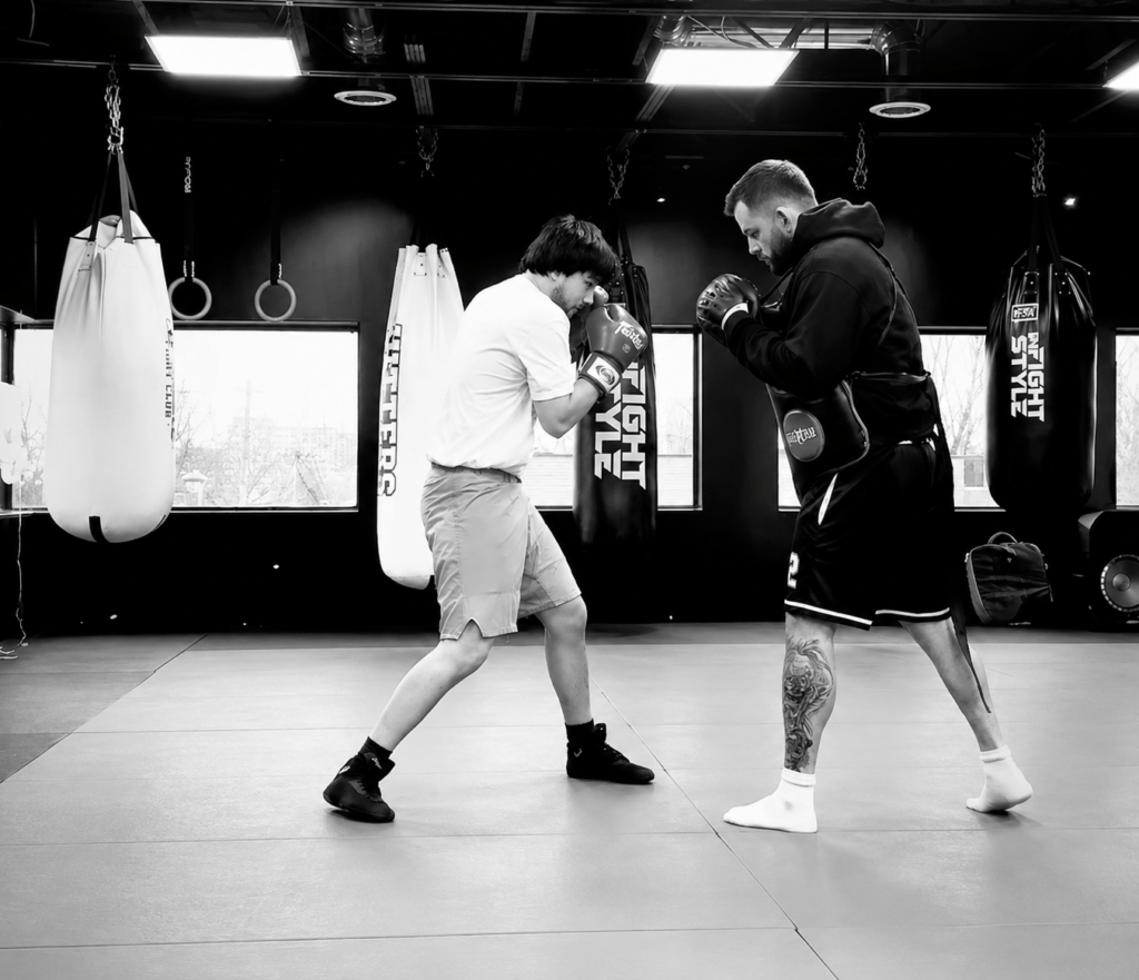 Beginner boxing student training with a coach during a boxing class at Hitters Fight Club Toronto.