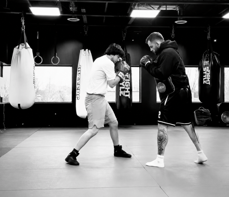 Beginner boxing student training with a coach during a boxing class at Hitters Fight Club Toronto.