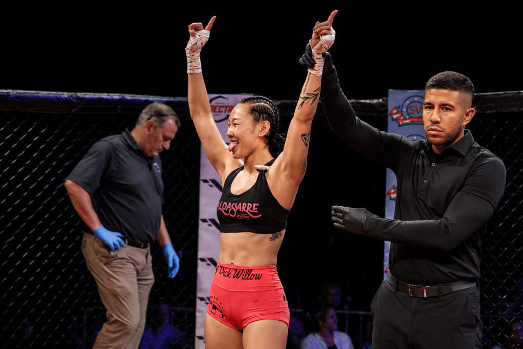 Willow Morton celebrates her MMA victory after having her hand raised by the referee at BTC, representing Hitters Fight Club Toronto.